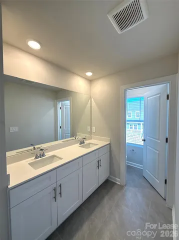 a bathroom with a double vanity sink and mirror with shower