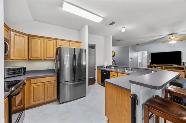 a kitchen with stainless steel appliances a refrigerator and a stove top oven