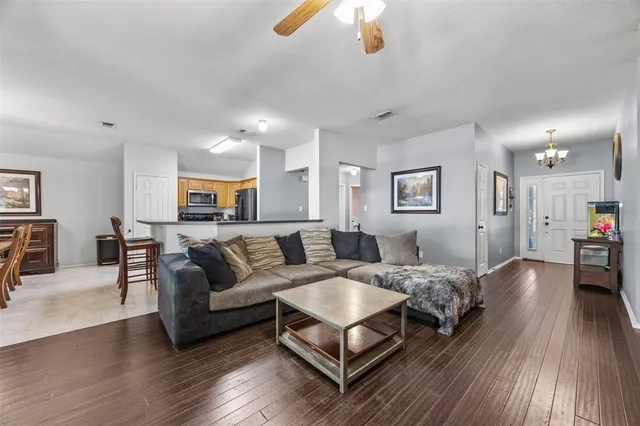 a living room with furniture and a wooden floor