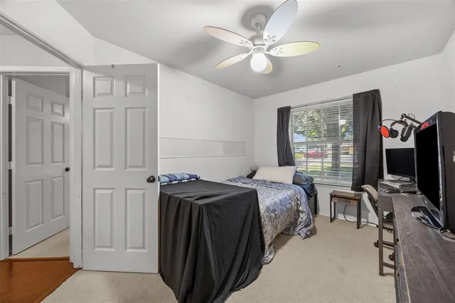 a bedroom with a bed closet and a flat tv screen