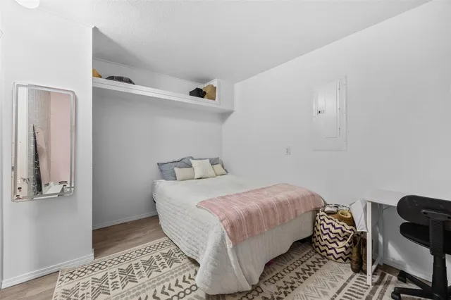 a bedroom with a bed and wooden floor