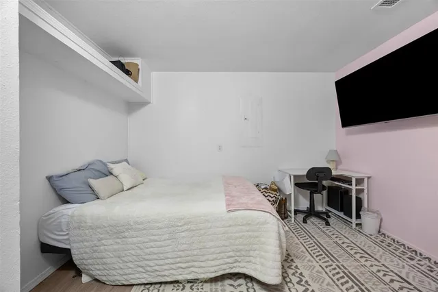 a bedroom with a bed and a flat screen tv