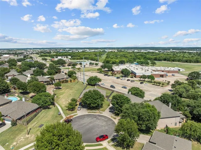 an aerial view of residential houses with outdoor space and trees