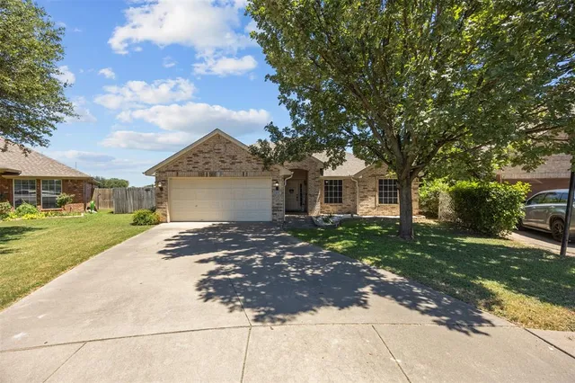 a view of a white house with a yard and large tree