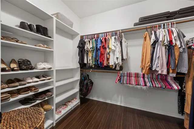 a view of walk in closet with clothes and shoes