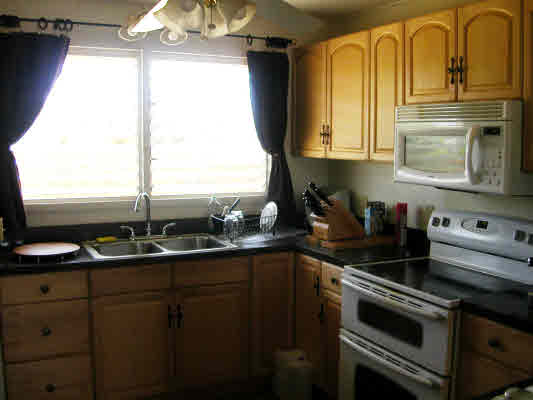 4896 Nunu Road Kapaa, HI 96746 - Photo 2 of 10 a kitchen with stainless steel appliances a sink a stove and cabinets