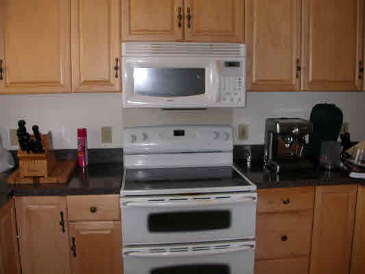 4896 Nunu Road Kapaa, HI 96746 - Photo 3 of 10 a kitchen with granite countertop white cabinets and white appliances