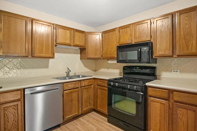 a kitchen with granite countertop wooden cabinets and a stove top oven