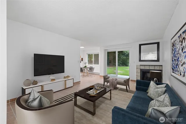 a living room with furniture a flat screen tv and a fireplace