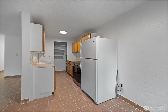 a kitchen with a refrigerator sink stove and cabinets