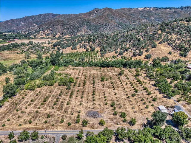 an aerial view of house with yard and mountain view in back