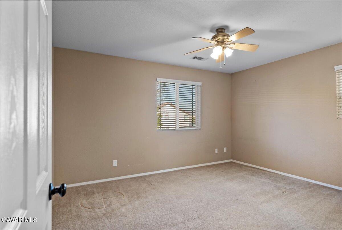 1450 Green Street Tehachapi, CA 93561 - Photo 13 of 27 an empty room with a chandelier fan and windows