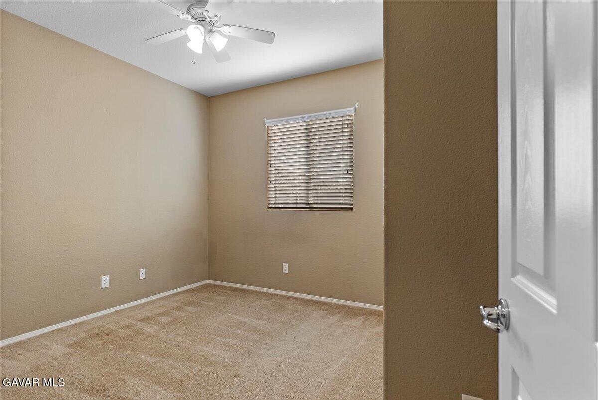1450 Green Street Tehachapi, CA 93561 - Photo 6 of 27 an empty room with a chandelier fan and windows