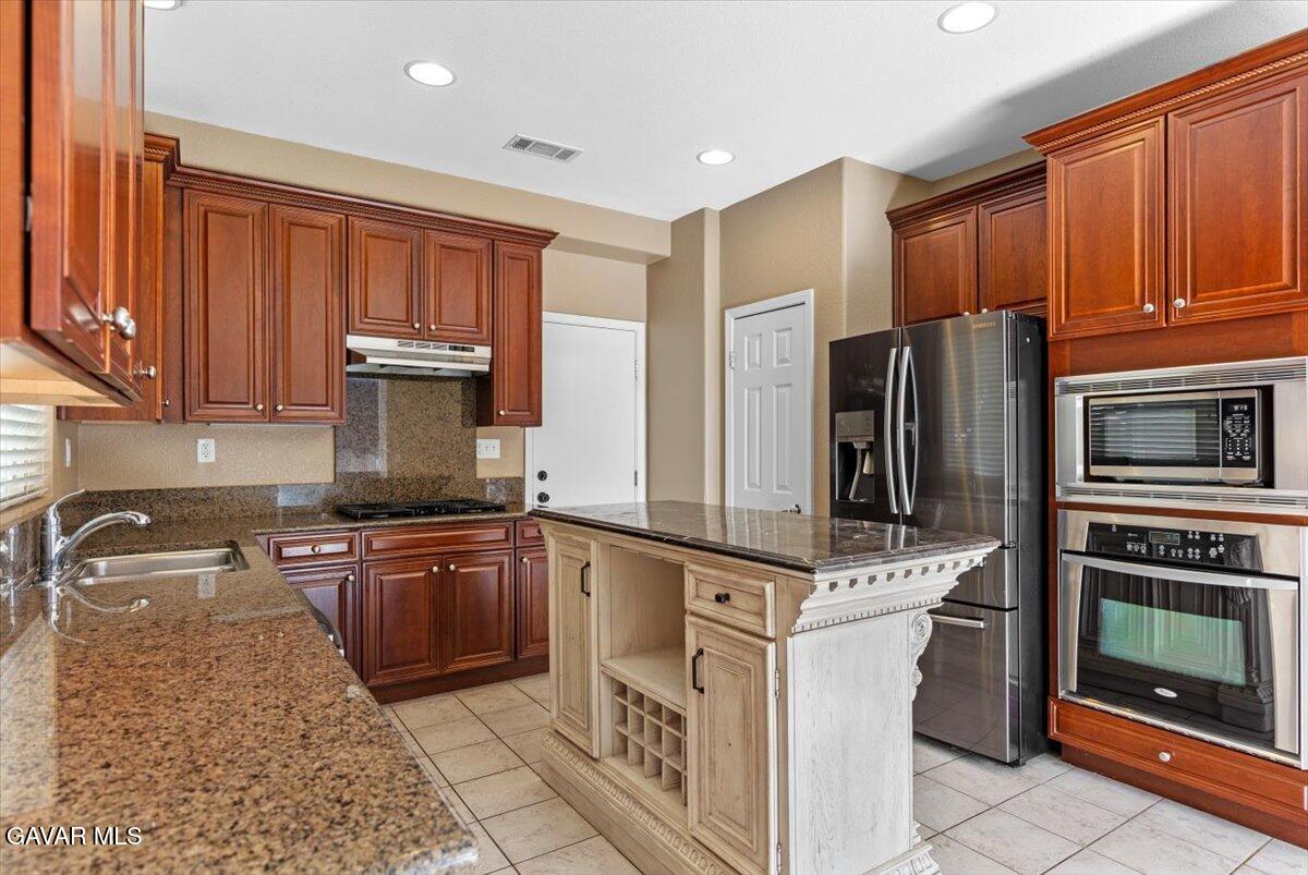 1450 Green Street Tehachapi, CA 93561 - Photo 8 of 27 a kitchen with stainless steel appliances granite countertop a refrigerator stove top oven and sink