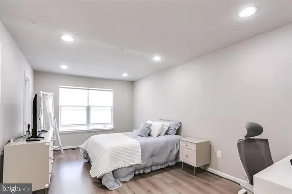 a bedroom with bed and window with wooden floor