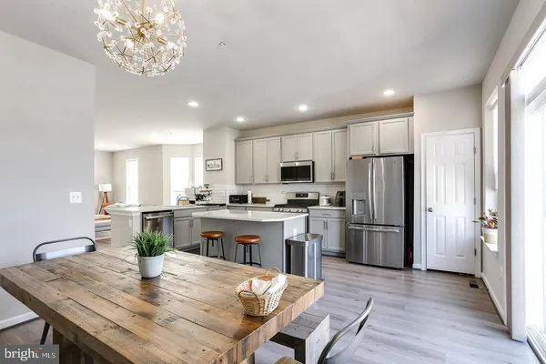 a kitchen with refrigerator cabinets dining table and chairs