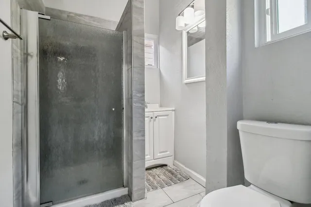 a bedroom with a large bed and a potted plant