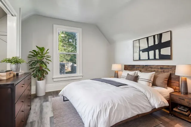 an empty room with wooden floor and staircase
