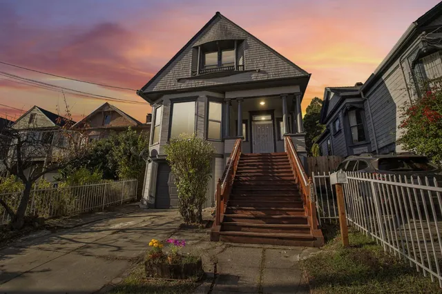 a view of house with wooden stairs and a potted plant
