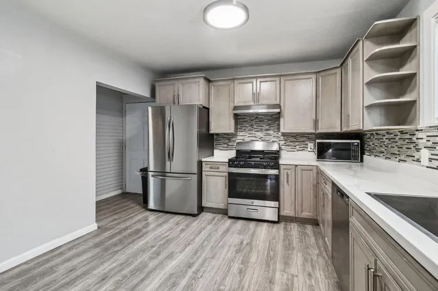 a view of an empty room with wooden floor and closet