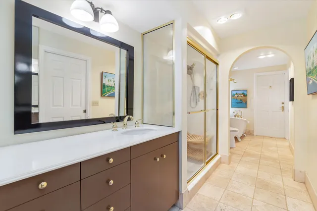 a spacious bathroom with a granite countertop sink mirror and a shower