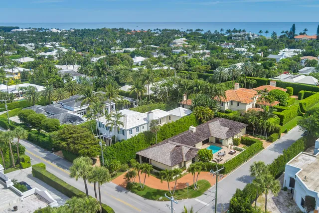 an aerial view of residential houses with outdoor space and trees