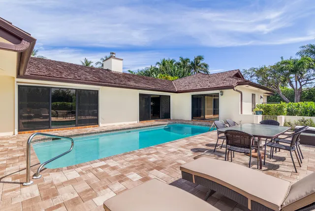 a view of a house with backyard and sitting area