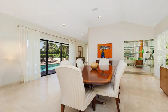 a dining room with furniture and a floor to ceiling window