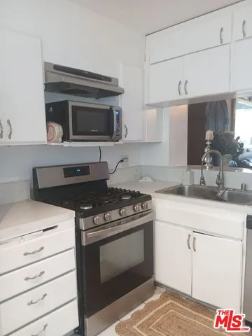 a kitchen with stainless steel appliances granite countertop a stove and a sink