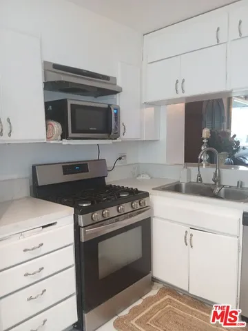 a kitchen with stainless steel appliances granite countertop a stove and a sink