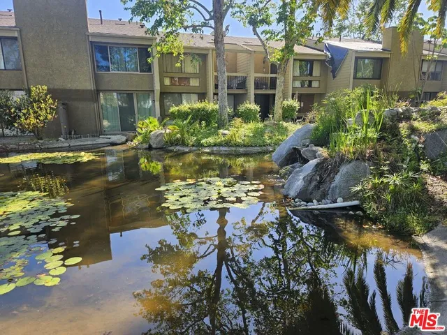 a front view of a house with a yard and swimming pool