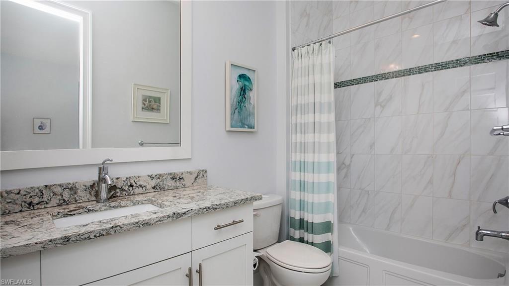 5060 Martinique Drive Naples, FL 34113 - Photo 17 of 38 a bathroom with a granite countertop sink a toilet and shower
