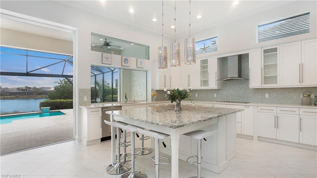 5060 Martinique Drive Naples, FL 34113 - Photo 5 of 38 a kitchen with center island table and chairs