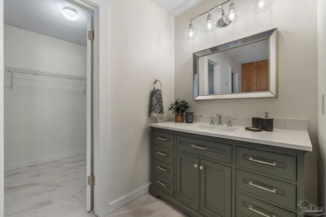 a bathroom with a granite countertop sink vanity and mirror