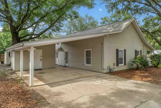 a view of backyard with a barn and a large tree