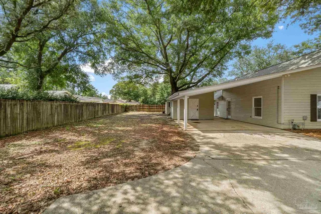 a backyard of a house with table and chairs