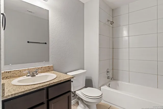 a bathroom with a granite countertop sink toilet and shower