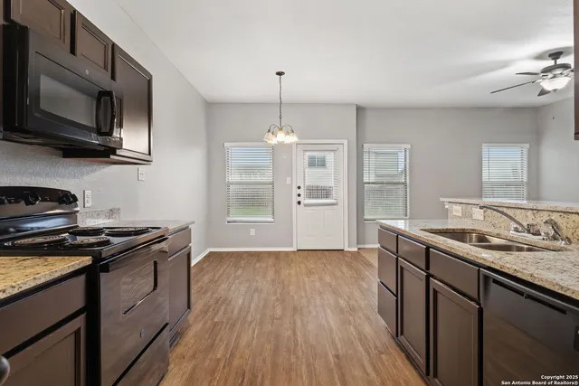 a kitchen with stainless steel appliances granite countertop a sink stove and cabinets