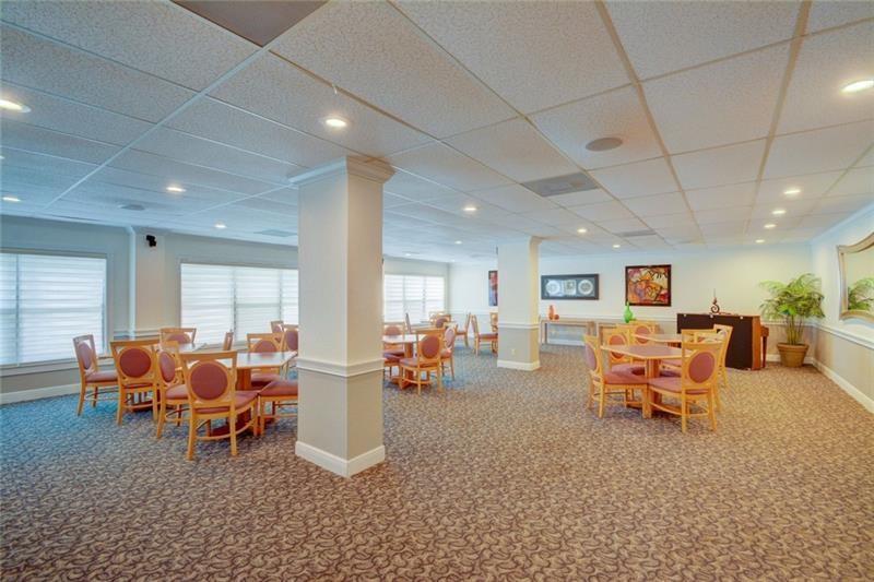 10777 West Sample Road, Unit 1104 Coral Springs, FL 33065 - Photo 11 of 25 a living room with furniture and kitchen view