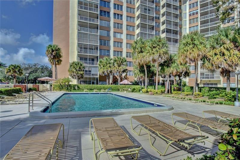 10777 West Sample Road, Unit 1104 Coral Springs, FL 33065 - Photo 13 of 25 front view of a building with a yard