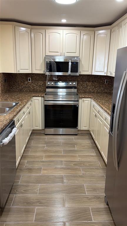 10777 West Sample Road, Unit 1104 Coral Springs, FL 33065 - Photo 15 of 25 a kitchen with granite countertop a stove and cabinets