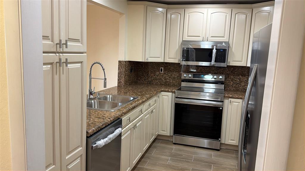10777 West Sample Road, Unit 1104 Coral Springs, FL 33065 - Photo 16 of 25 a kitchen with stainless steel appliances granite countertop a stove and a microwave