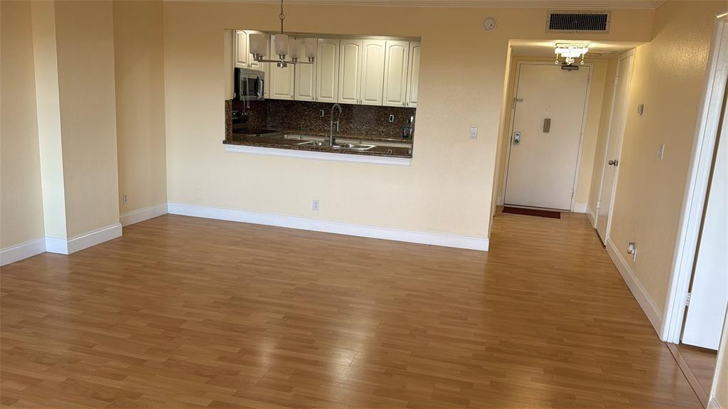 10777 West Sample Road, Unit 1104 Coral Springs, FL 33065 - Photo 17 of 25 a view of a room with wooden floor and a ceiling fan