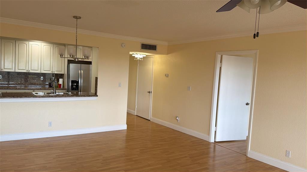 10777 West Sample Road, Unit 1104 Coral Springs, FL 33065 - Photo 18 of 25 a view of a kitchen with stainless steel appliances granite countertop cabinets and wooden floor