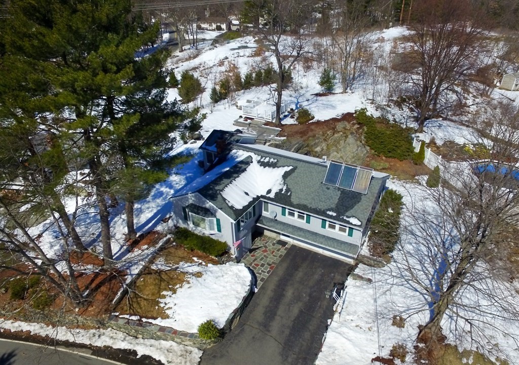 an aerial view of a house with a yard and mountain