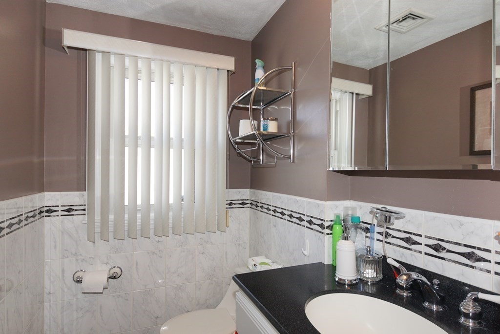 39 Locust Street Burlington, MA 01803 - Photo 3 of 27 a bathroom with a granite countertop sink and a mirror