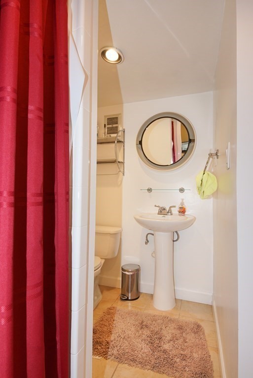 39 Locust Street Burlington, MA 01803 - Photo 4 of 27 a bathroom with a sink a mirror and a shower curtain