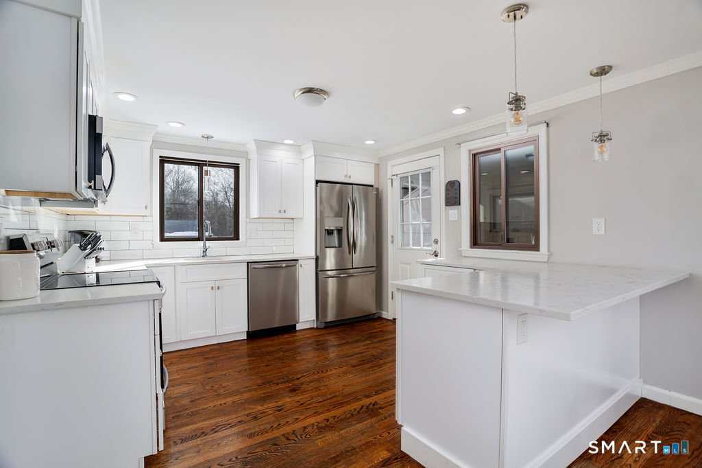 245 Reid Street Fairfield, CT 06824 - Photo 11 of 33 a kitchen with a refrigerator sink and cabinets