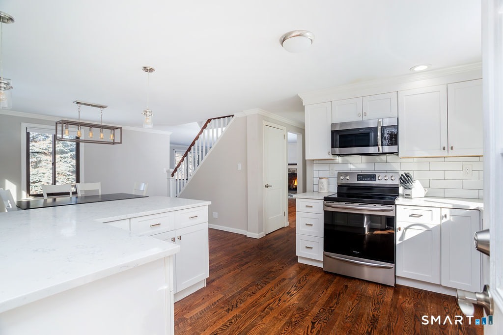 245 Reid Street Fairfield, CT 06824 - Photo 13 of 33 a kitchen with a sink a microwave and cabinets