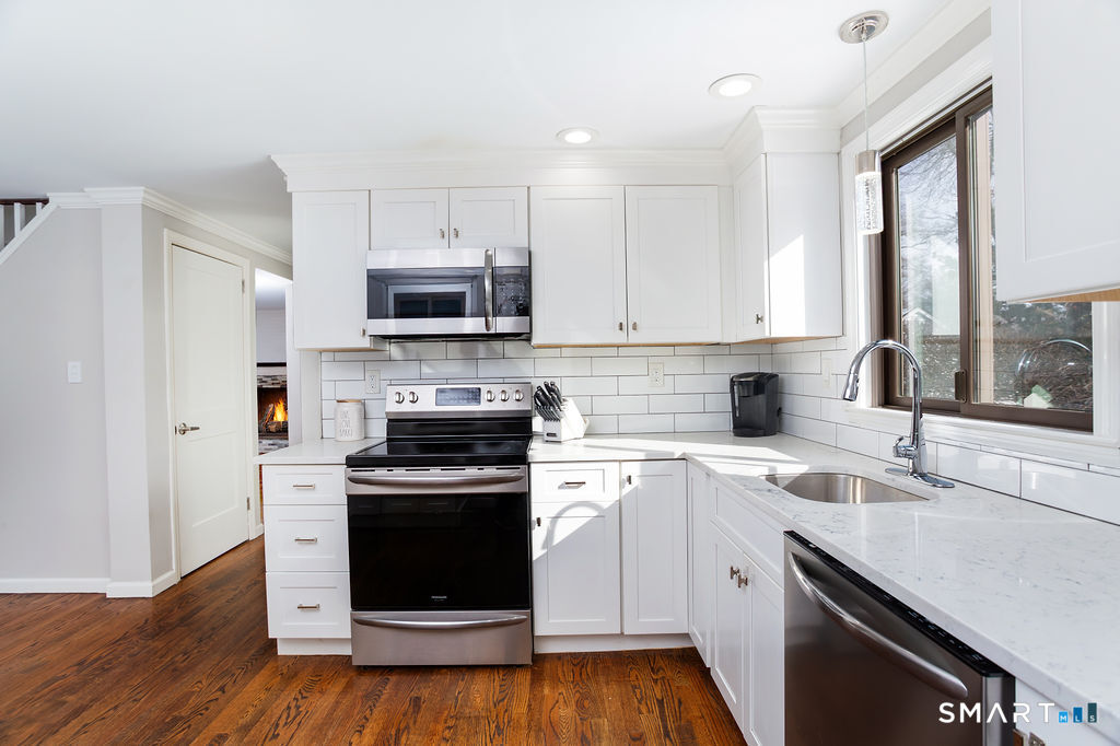 245 Reid Street Fairfield, CT 06824 - Photo 14 of 33 a kitchen with a sink stove and microwave
